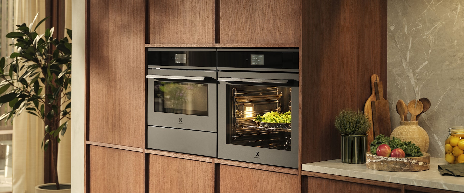 Kitchen view with vegetables on table and Ovens in the back